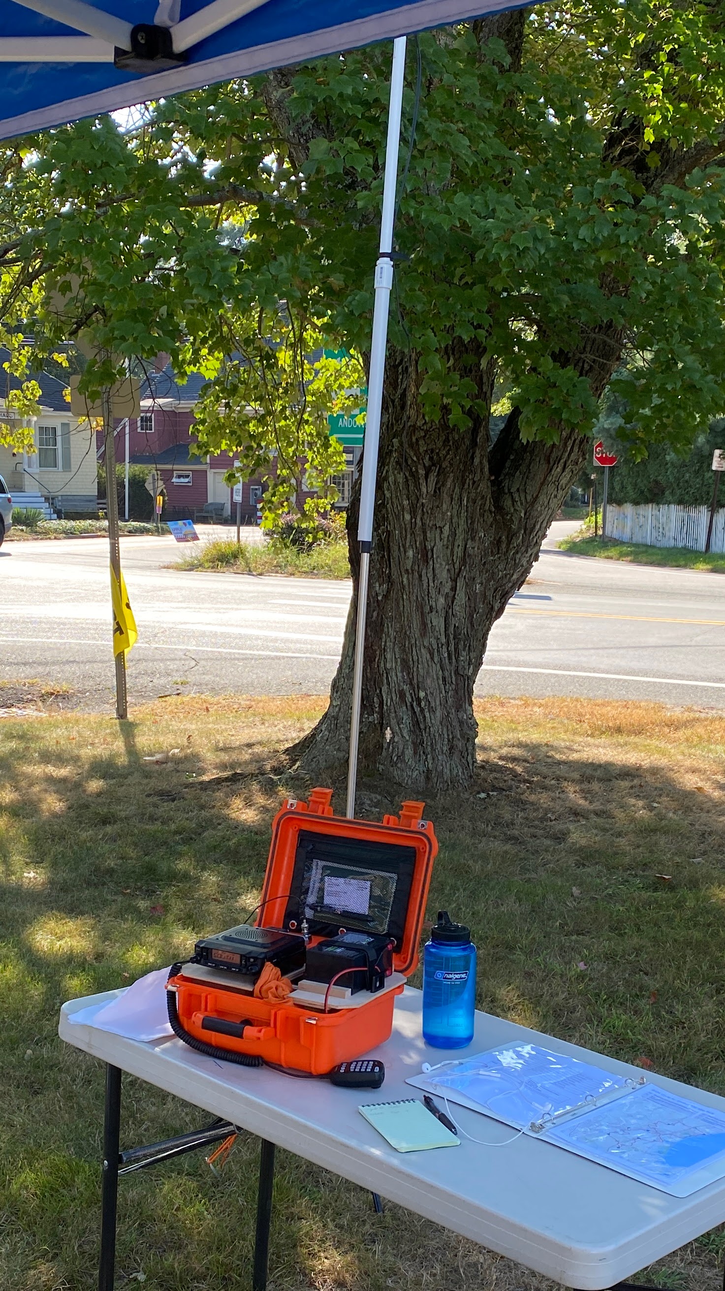 Mobile radio deployed on a folding table with atenna mast on a tripod in the background