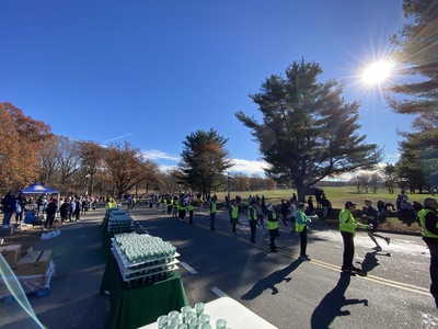 Picture of volunteers holding out cups of water to runners